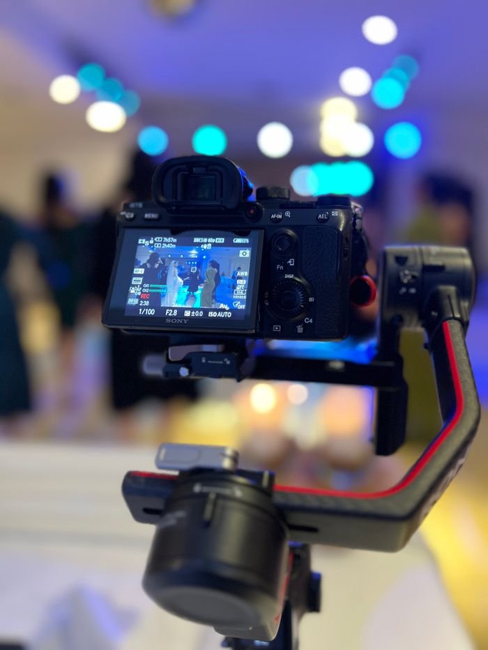 Close-up of a professional camera mounted on a gimbal, capturing a vibrant setting.